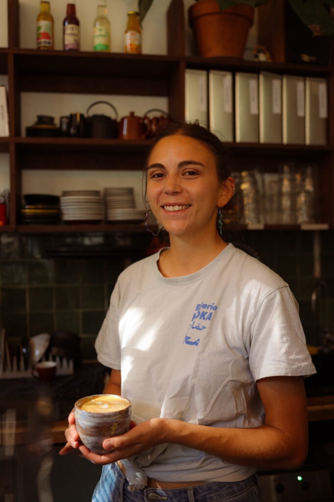 Une barista MÖKA au comptoir du coffee-shop, une tasse à la main
